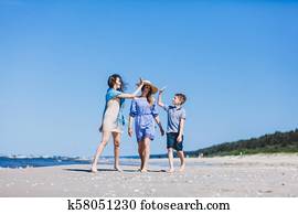Mother with children walking by the sea