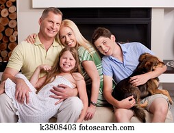 Happy domestic family sitting in living room with dog