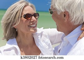 Happy Senior Couple Dancing Holding Hands on A Tropical Beach