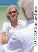 Happy Senior Couple Dancing Holding Hands on A Tropical Beach