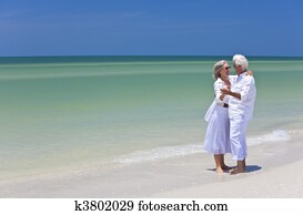 Happy Senior Couple Dancing Holding Hands on Tropical Beach