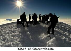 group of people on the summit of a high mountain