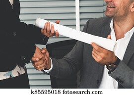 Businessman handshake businesswoman in office.