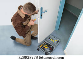 Carpenter Fixing Lock With Screwdriver Carpenter Fixing Lock With Screwdriver