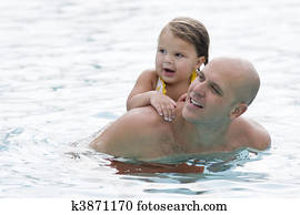 Young girl getting piggyback ride from dad in pool Young girl getting piggyback ride from dad in pool