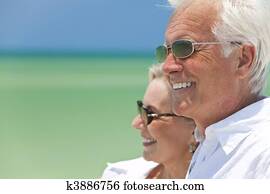 Happy Senior Couple Looking To Sea on A Tropical Beach