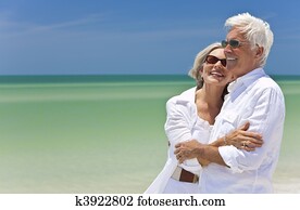 Happy Senior Couple Looking To Sea on A Tropical Beach