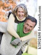 Senior man giving woman piggyback ride Senior man giving woman piggyback ride