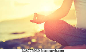 Yoga concept. hand woman practicing lotus pose on beach 
