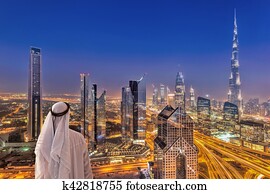 árabe, homem, observar, noturna, cityscape, de, dubai, com, modernos, futurista, arquitetura, em, emirates árabes unidos