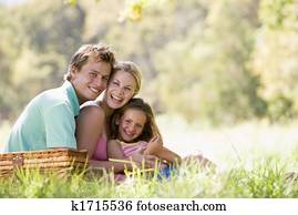 Family at park having a picnic and laughing Family at park having a picnic and laughing