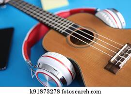 Acoustic guitar with headphones lies on table