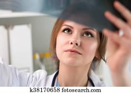 Young female doctor looking at lungs x-ray
