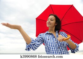 woman with red umbrella touching the rain woman with red umbrella touching the rain