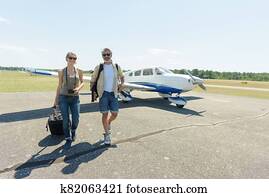 rich young couple departing from private plane rich young couple departing from private plane