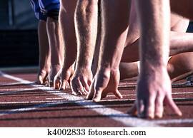 The start line up of runners hands at an athletics race.