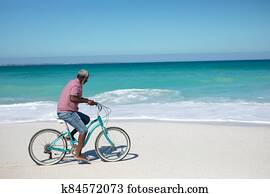 Old man with a bike at the beach Old man with a bike at the beach