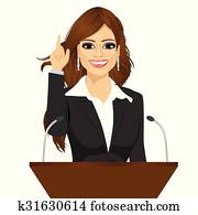 female orator standing behind a podium with microphones female orator standing behind a podium with microphones