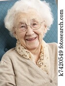 Senior Woman Relaxing In Chair At Home