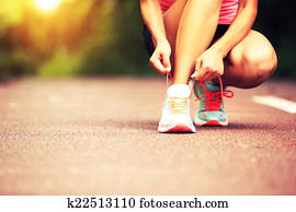 young woman runner tying shoelaces young woman runner tying shoelaces