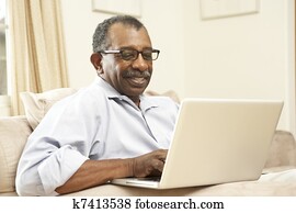 hombre mayor, usar la computadora portátil, en casa