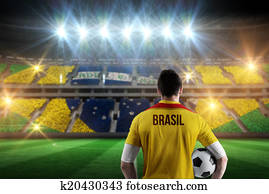 Composite image of brasil football player holding ball Composite image of brasil football player holding ball