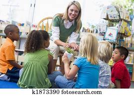 Kindergarten teacher and children looking at seedling in library Kindergarten teacher and children looking at seedling in library