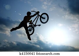 schaduwfiguur, van, jongen, met, fietsje, het springen in, lucht