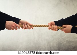 Tug of war. Hands pulling rope to opposite sides