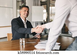 empresa / negocio, carrera, y, colocación, concepto, -, satisfecho, director, hombre, 30s, sonriente, y, sacudarir las manos, con, macho, candidato, quién, era, recruited, durante, entrevista, en, oficina
