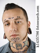 Man with tattoos and piercings.