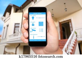 male hand hold a phone with system clever house on a screen on the background of the house