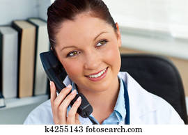 Attractive female doctor phoning in her office
