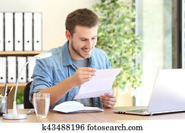 Happy entrepreneur reading a letter Happy entrepreneur reading a letter