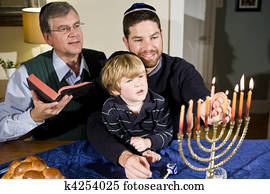 Jewish family lighting Hanukkah menorah