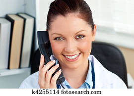 Smiling female doctor phoning in her office