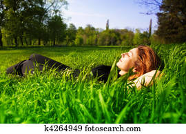 Carefree concept - woman relaxing outdoor in grass