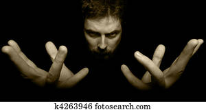Hands and face of evil magician in the dark Hands and face of evil magician in the dark