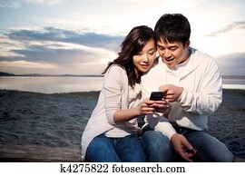 Asian couple texting