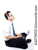 Young man sitting and using a laptop listen to the music