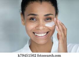 Close up face african beautiful woman apply cream on skin Close up face african beautiful woman apply cream on skin