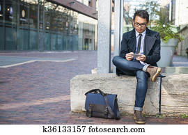 Young asian man looking at mobile phone