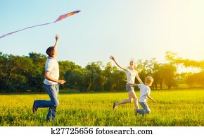 Dad, mom and son child flying a kite in summer nature Dad, mom and son child flying a kite in summer nature