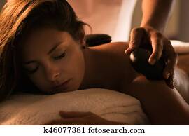 The girl enjoys stone therapy treatment.