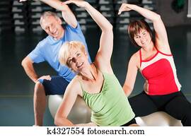 People in gym on exercise ball People in gym on exercise ball