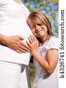 pregnancy - girl touching belly of pregnant mother
