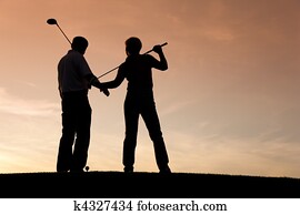 Senior couple playing Golf at sunset Senior couple playing Golf at sunset