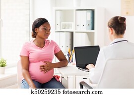 doctor with laptop and pregnant woman at clinic doctor with laptop and pregnant woman at clinic