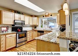 Bright kitchen with granite tops and skylight