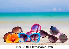 many sunglasses lying on tropical lying beach